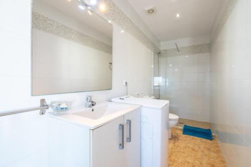 a white bathroom with a sink and a toilet at Wonderful in Can Picafort