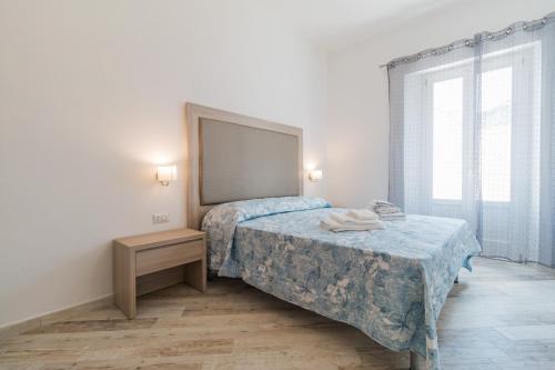 a bedroom with a bed and a table and a window at Appartamento Blu in Dorgali