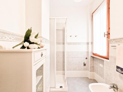 a white bathroom with a sink and a shower at Bilo Le Lecce 15b in Capoliveri