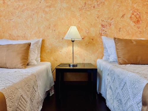 a room with two beds and a lamp on a table at Casa Cataleia VILLA INN in Ponte de Lima