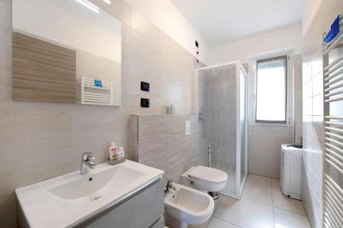 a white bathroom with a sink and a toilet at Appartamento 7 Il Tornante in Nesso