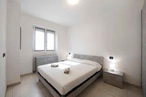 a white bedroom with a bed and a window at Appartamento 7 Il Tornante in Nesso