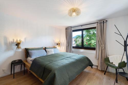 a bedroom with a green bed and a window at Haus Schwarzwald Königin in Bühlertal