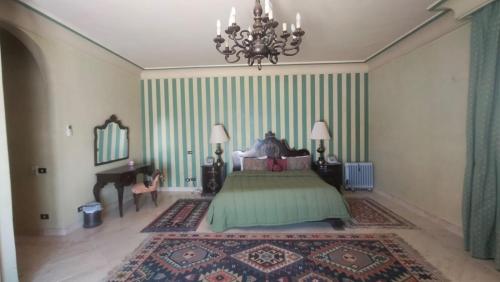 a bedroom with a bed with a chandelier and a piano at Hurghada Beach House in Hurghada