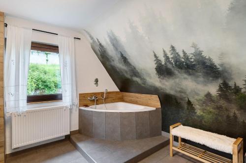a bathroom with a bath tub and a painting on the wall at Haus Schwarzwald Königin in Bühlertal