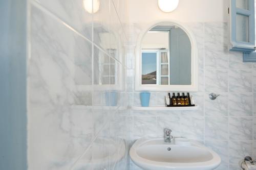 a white bathroom with a sink and a mirror at Pico Bello Patmos 16 in Patmos