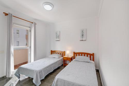 two beds in a white room with a window at Casa Goro in Tazacorte