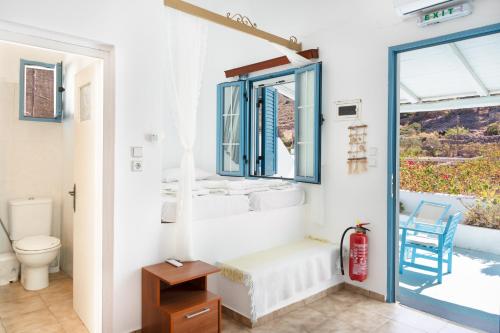 a bathroom with a toilet and a window at Beachfront Lampis Dolphin 3 in Skala