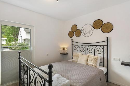 a bedroom with a black bed and a window at Casa Verde Sauerland in Lennestadt