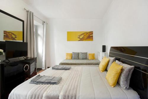 a bedroom with a large bed with yellow and gray pillows at Carros De Cesto Do Monte in Funchal