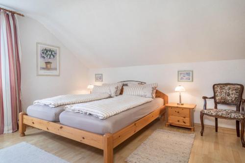 a bedroom with a bed and a chair at Annemarie und Walter Hechelmann in Lindau