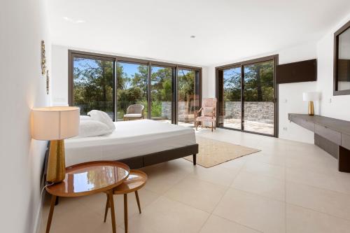 a bedroom with a bed and a table and some windows at Villa Valériane in Trans-en-Provence