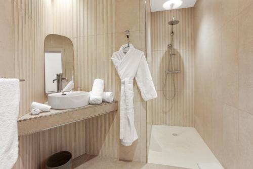 a bathroom with a sink and a white robe at Villa Valériane in Trans-en-Provence