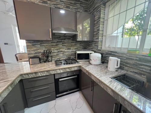 a kitchen with a counter with a stove top oven at Luxe Mini-Suite Maharagama in Maharagama