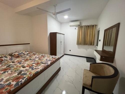 a bedroom with a bed and a chair in it at Luxe Mini-Suite Maharagama in Maharagama