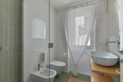 a bathroom with a sink and a toilet and a shower at Casa Azzurrina Mare in Seccheto