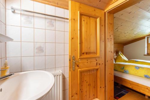 a bathroom with a tub and a bed in a room at Ferienwohnung Weissbacher in Sankt Martin bei Lofer
