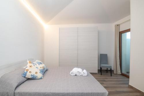 a bedroom with a bed with two pairs of slippers at Mavi Primo Piano in Palau