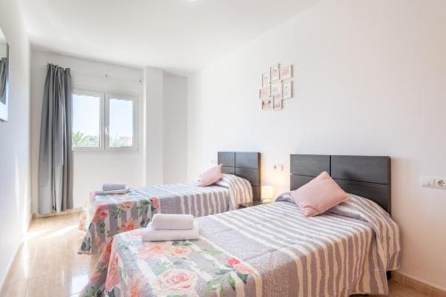 a bedroom with two beds and two windows at Ferrera Soul 2b in Felanitx