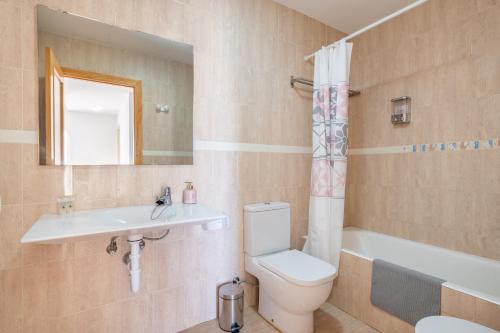 a bathroom with a toilet and a sink and a mirror at Ferrera Soul 2b in Felanitx