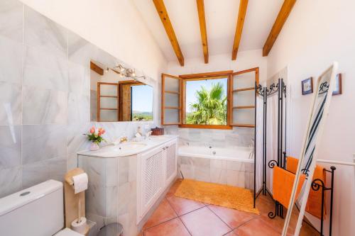 a bathroom with a tub and a sink and a toilet at Can Carboneta in Artá