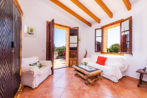 a living room with two white couches and a table at Can Carboneta in Artá