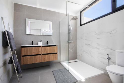 a bathroom with a shower and a sink and a toilet at Las Cuestitas Relax in Pájara