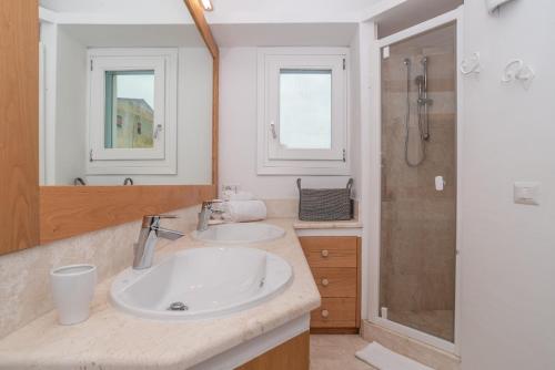 a bathroom with two sinks and a shower at Charming house in San Pantaleo in Olbia