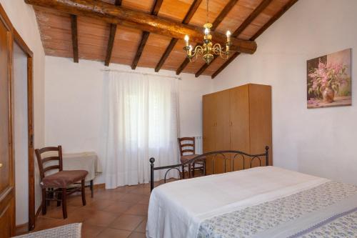 a bedroom with a bed and a table and chairs at Agriturismo Il Badalo in Riparbella