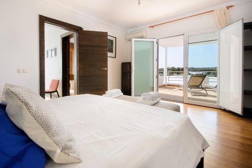 a bedroom with a large white bed and a balcony at Las Perseidas in Costa Teguise