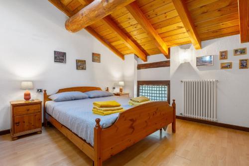a bedroom with a bed and a wooden ceiling at La Mansarda del Viaggiatore in Pont-Saint-Martin
