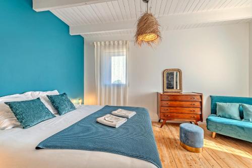 a blue bedroom with a bed and a blue chair at Villa Léonie - piscine intérieure in Kerlouan