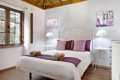 a bedroom with a large white bed with towels on it at Casa Golondrina in Teguise