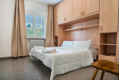 a bedroom with a large white bed and a window at Lases Piano Terra in Albiano