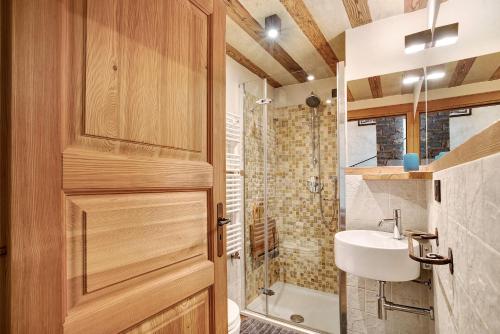 a bathroom with a wooden door and a sink at Il Cuore della Valdigne in Morgex