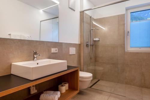 a bathroom with a sink and a shower and a toilet at Ferienwohnungen Karin - Cabernet in Termeno