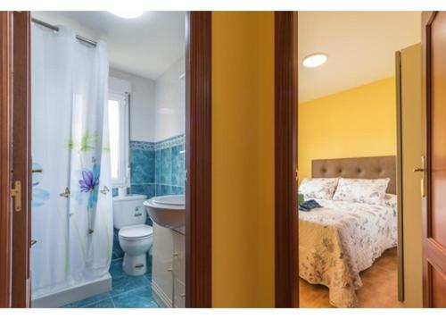 a bedroom with a bed and a bathroom with a sink at El Trabaz in Candamin