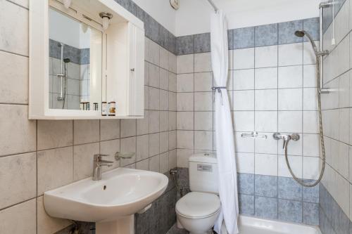 a bathroom with a sink and a toilet and a shower at Anemologio 202 Studio Tinos in Agios Ioannis