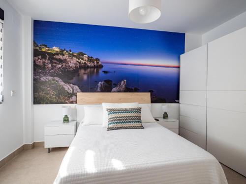 a bedroom with a bed with a painting on the wall at 'Mi Esperanza' in Almuñécar