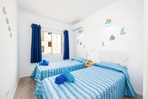 two beds in a bedroom with blue sheets at Gran Sol Family 6 in Felanitx