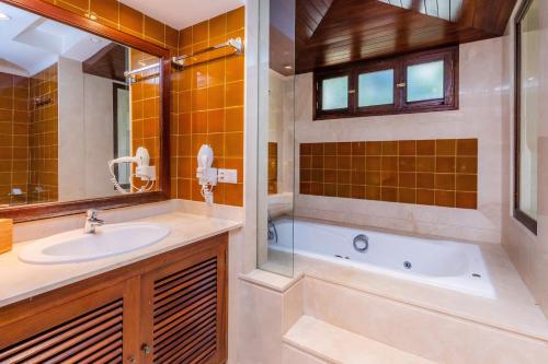 a bathroom with a tub and a sink and a shower at Villa Beach Palmitos in Can Picafort