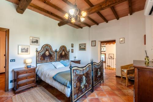 a bedroom with a large bed and a wooden ceiling at Pietraserena - San Gimignano in San Gimignano