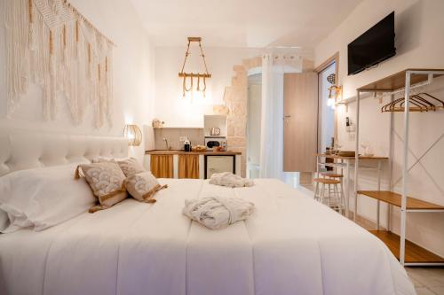 a white bedroom with a large white bed at Dimora Giulia in Castellana Grotte