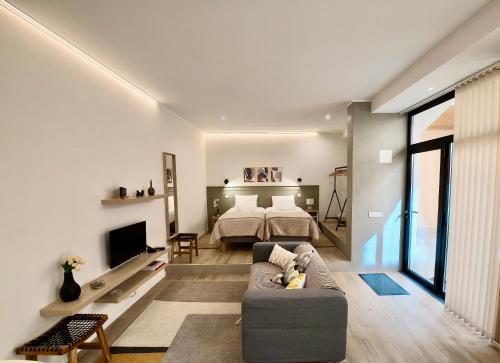 a living room with a bed and a couch at Ladomar Avenida in Horta