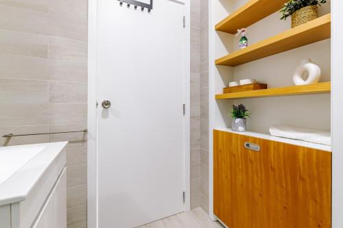a bathroom with a wooden door next to a sink at Ladomar Avenida in Horta