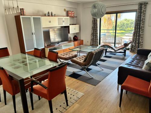 a living room with a glass table and chairs at Atlantic Lodge, 1ª linha de praia! in Costa da Caparica