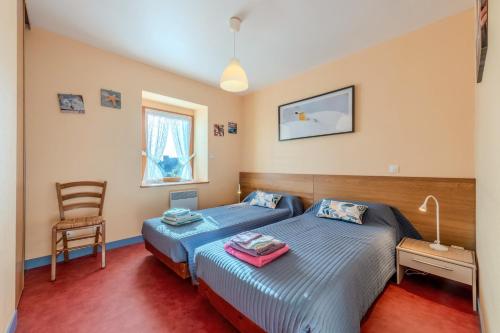 a bedroom with a blue bed and a chair at Maison de caractère à Roscoff in Roscoff