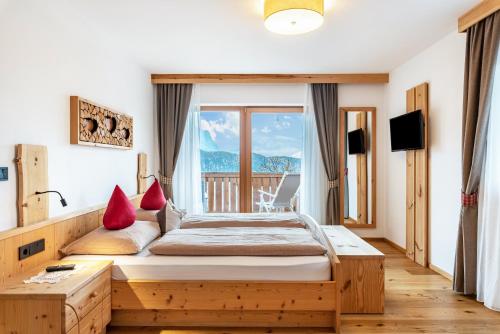 a bedroom with a bed and a large window at Hatzes App Schlern in Laion