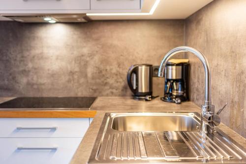 a kitchen with a sink and a coffee maker at Hatzes App Schlern in Laion