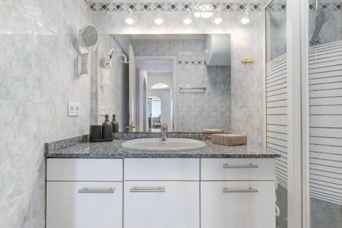 a white bathroom with a sink and a mirror at Bungalow Seaview in San Bartolomé